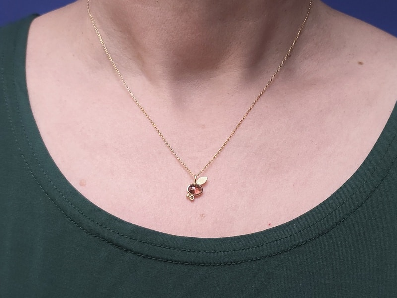 Gouden hanger met rode toermalijn, diamant, besje en blaadje uit de 'Verzameling' serie. Een unieke verfijnde Oogst Original. Gezien om de hals.