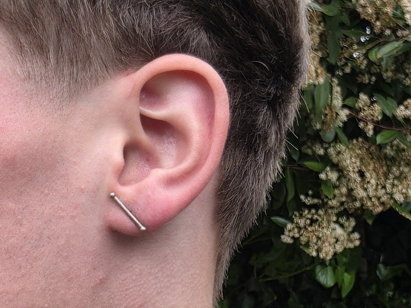 White gold rod with small berries ear studs. Minimal design by Oogst Jewellery. See on the earlobe.